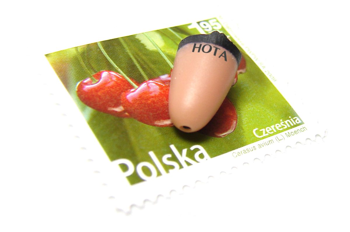 Mikrosłuchawka położona na polskim znaczku pocztowym