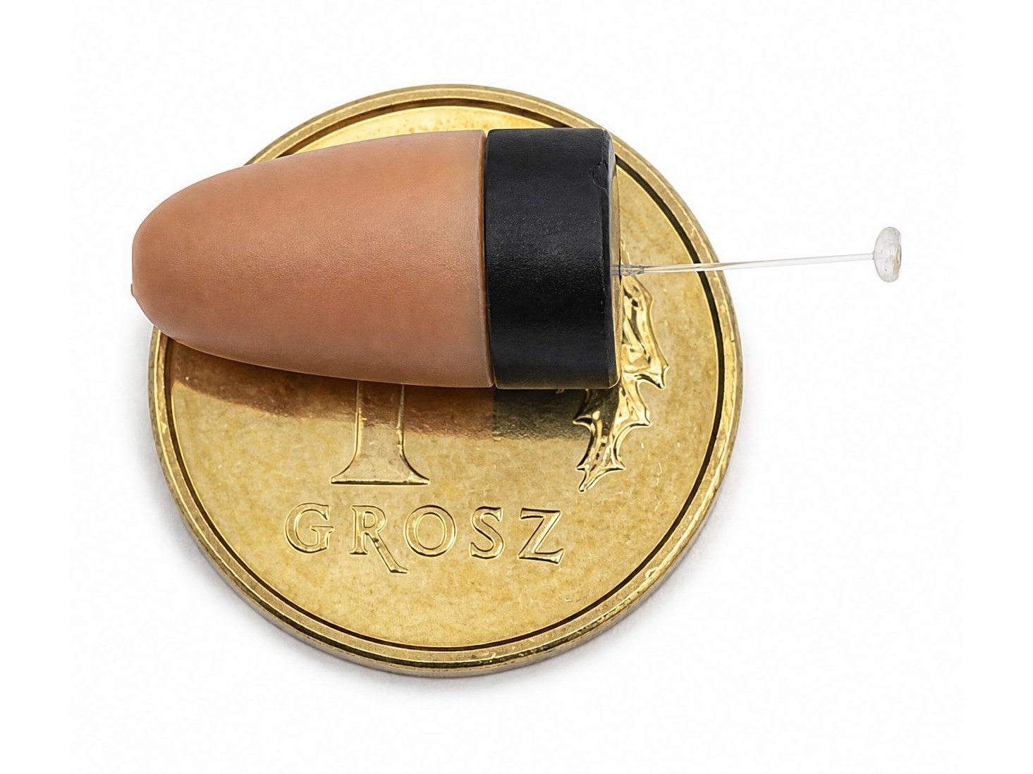 Microauricular sobre una moneda de 1 grosz visto desde arriba
